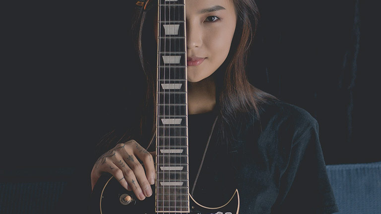 Girl smiling with an electric guitar