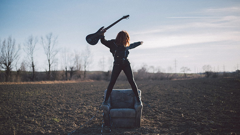 Women enjoying playing guitar outdoors