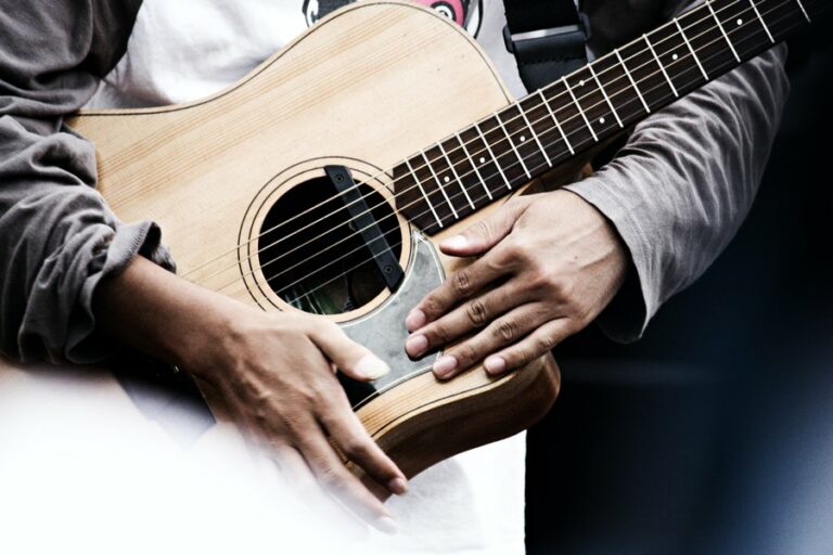 Man holding acoustic-electric (electro-acoustic) guitar